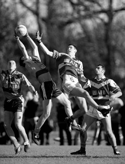 John Golden goes up for the ball against UCD in Sigerson 2001, as Teu O'Hailpin watches on from the ground.